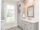 Bright bathroom featuring a window, glass doored shower, and vanity with elegant fixtures at 3403 Raccoon Run Dr, Burlington, NC 27215