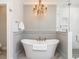 Elegant bathroom featuring a freestanding tub, chandelier, and glass-enclosed shower at 3403 Raccoon Run Dr, Burlington, NC 27215