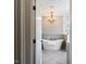Elegant bathroom featuring a freestanding tub, chandelier, and herringbone tile floors at 3403 Raccoon Run Dr, Burlington, NC 27215