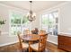 Dining room with hardwood floors, chandelier, lots of natural light from the large windows with blinds at 3403 Raccoon Run Dr, Burlington, NC 27215
