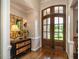 Elegant foyer boasts hardwood floors, a stylish mirror, and a decorative wooden front door at 3403 Raccoon Run Dr, Burlington, NC 27215