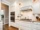 Modern kitchen showcasing stainless appliances, custom cabinetry, and a stylish range hood at 3403 Raccoon Run Dr, Burlington, NC 27215
