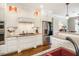 A kitchen area with white cabinets, granite counters, stainless steel appliances, and hardwood floors at 3403 Raccoon Run Dr, Burlington, NC 27215