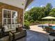 Relaxing covered patio with furniture, and backyard pool view at 3403 Raccoon Run Dr, Burlington, NC 27215