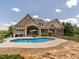 Resort-style backyard with a sparkling pool and stone patio at 3403 Raccoon Run Dr, Burlington, NC 27215