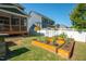 Landscaped backyard features raised garden beds and flowering trellises in a well-maintained lawn at 3678 Horton Hill Dr, New Hill, NC 27562