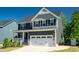 Charming two-story home featuring a two-car garage, yellow door, and inviting front porch, perfect for suburban living at 3678 Horton Hill Dr, New Hill, NC 27562