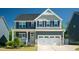 Charming two-story home featuring a two-car garage, yellow door, and inviting front porch, perfect for suburban living at 3678 Horton Hill Dr, New Hill, NC 27562
