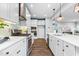 A modern kitchen featuring a stainless steel stove and hood, white cabinets, white counter tops, and hardwood floors at 3678 Horton Hill Dr, New Hill, NC 27562