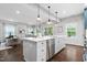 A modern, eat-in kitchen featuring pendant lighting, stainless steel appliances, and a large island with a white countertop at 3678 Horton Hill Dr, New Hill, NC 27562