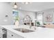A modern kitchen island featuring stainless steel sink, white counter tops, and views of the living room at 3678 Horton Hill Dr, New Hill, NC 27562