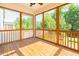 Inviting screen porch with wood flooring, vaulted ceiling, and scenic backyard views at 3678 Horton Hill Dr, New Hill, NC 27562