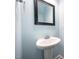 Stylish half-bathroom featuring a pedestal sink, modern fixtures, and fresh, light blue paint at 3945 Amelia Park Dr, Raleigh, NC 27606