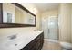 A spacious bathroom with a dual sink vanity, large framed mirror, and a glass enclosed walk-in shower at 3945 Amelia Park Dr, Raleigh, NC 27606