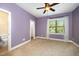 Bedroom with neutral carpet, a ceiling fan, an outside window and a bathroom with a toilet at 3945 Amelia Park Dr, Raleigh, NC 27606