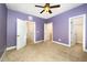 The purple-painted bedroom features neutral carpet and multiple closets or entryways at 3945 Amelia Park Dr, Raleigh, NC 27606
