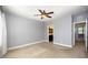 A gray bedroom features neutral carpeting and a ceiling fan, with the bathroom located through an adjacent door at 3945 Amelia Park Dr, Raleigh, NC 27606