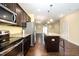 Open kitchen with stainless steel appliances, granite countertops, dark cabinetry, and a center island at 3945 Amelia Park Dr, Raleigh, NC 27606