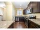 Modern kitchen features stainless steel appliances, dark wood cabinets, granite countertops, and hardwood floors at 3945 Amelia Park Dr, Raleigh, NC 27606