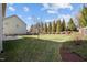 Picture of a backyard with a large grassy lawn, mature trees, and a patio seating area at 4 Seawell Ct, Durham, NC 27703