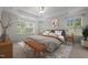 This bedroom features tray ceilings, lots of light from the two windows, and a bench at the end of the bed at 4 Seawell Ct, Durham, NC 27703