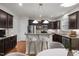 Well-lit kitchen features stainless steel appliances, dark cabinets, and an island with barstool seating at 4 Seawell Ct, Durham, NC 27703