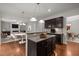 Open concept kitchen features dark wood cabinetry, granite countertops, and hardwood flooring at 4 Seawell Ct, Durham, NC 27703
