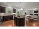 Bright kitchen boasts stainless appliances, dark wood cabinets, granite counters, and an open view of living area at 4 Seawell Ct, Durham, NC 27703