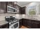 Well-equipped kitchen featuring stainless steel appliances, granite countertops, and dark wood cabinets at 4 Seawell Ct, Durham, NC 27703