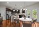 Spacious kitchen featuring stainless steel appliances, dark cabinets, granite counters, and an adjacent dining area at 4 Seawell Ct, Durham, NC 27703
