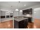 Open concept kitchen features dark wood cabinetry, granite countertops, and hardwood flooring at 4 Seawell Ct, Durham, NC 27703