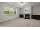Bright living room with a fireplace, large window, neutral decor, and carpeted floors at 4 Seawell Ct, Durham, NC 27703