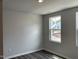 Bedroom with gray walls, window with view of outdoors and wood look flooring at 4002 Silver Oak Ln, Durham, NC 27703
