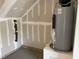 Unfinished garage interior with sealed concrete floors, sealed drywall, and water heater at 4002 Silver Oak Ln, Durham, NC 27703