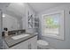 Bathroom featuring a modern vanity, a toilet, and a large window for natural light at 401 Haywood St, Raleigh, NC 27601