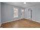 A light blue living room with wood flooring, updated ceiling fan, and a white front door at 401 Haywood St, Raleigh, NC 27601