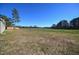 Expansive, mostly cleared backyard featuring mature trees and a clear blue sky at 404 S Eastwood Dr, Benson, NC 27504