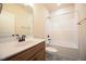 A bathroom featuring a single sink vanity, tile floors, toilet, and shower with tub at 404 S Eastwood Dr, Benson, NC 27504