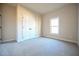 A carpeted bedroom featuring a window and a closet with folding double doors at 404 S Eastwood Dr, Benson, NC 27504