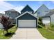Exterior shot of a blue house and attached garage, showing the driveway and landscaping at 43 Quarter Gate Trce, Chapel Hill, NC 27516