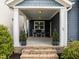 Inviting front porch with rocking chairs, brick steps, lush greenery, and a stylish front door at 43 Quarter Gate Trce, Chapel Hill, NC 27516
