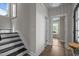 Elegant hallway with hardwood floors, staircase with black treads, and a glimpse of additional rooms at 43 Quarter Gate Trce, Chapel Hill, NC 27516