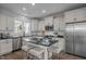 Modern kitchen with a center island and bar stool seating, stainless steel appliances and white cabinets at 43 Quarter Gate Trce, Chapel Hill, NC 27516