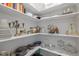 Organized pantry with white shelves stocked with cookware, glassware and other kitchen items at 43 Quarter Gate Trce, Chapel Hill, NC 27516