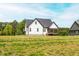 Rear exterior featuring black roof, white siding, and screened in porch at 474 Pine Ridge Rd, Zebulon, NC 27597