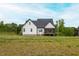 Back of house featuring black roof, white siding, and screened in porch at 474 Pine Ridge Rd, Zebulon, NC 27597