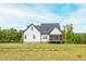 Spacious backyard showcasing a newly built home with a screened in porch and green yard at 474 Pine Ridge Rd, Zebulon, NC 27597