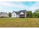 Rear exterior of a home with black roof, white siding, and screened porch at 474 Pine Ridge Rd, Zebulon, NC 27597