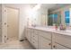 Bright bathroom featuring white cabinets and double sinks and marble style tiled floor at 474 Pine Ridge Rd, Zebulon, NC 27597