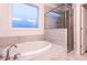 Bathroom with a drop-in tub with marble tile surround and glass shower at 474 Pine Ridge Rd, Zebulon, NC 27597